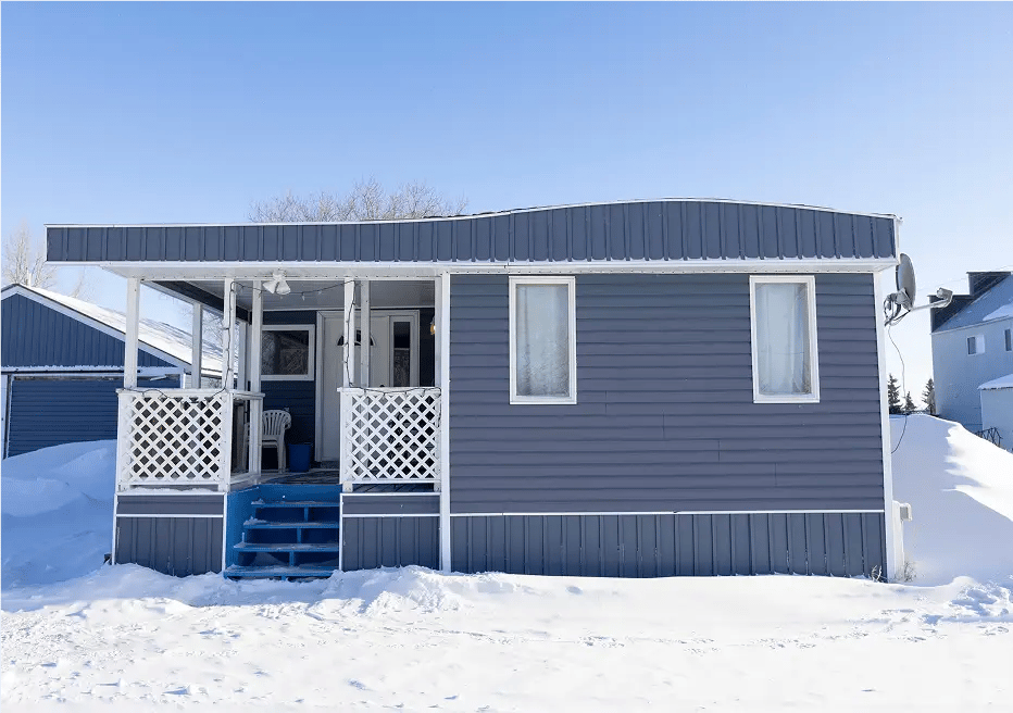 Exterior of nice blue-gray mobile home with sitting porch, latice.