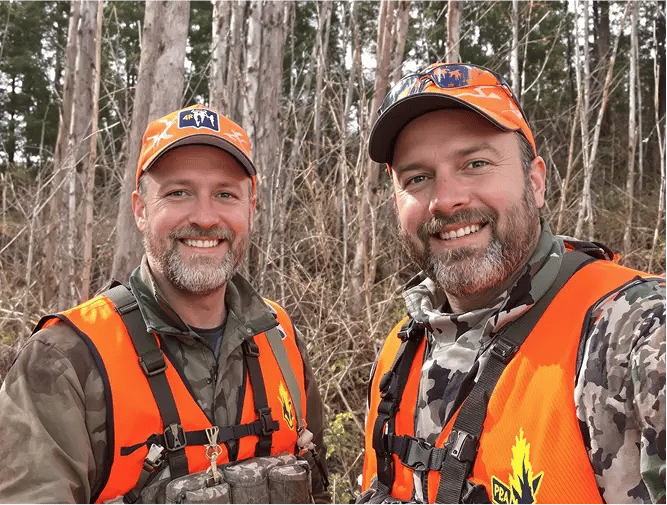 Hunters in orange vests.